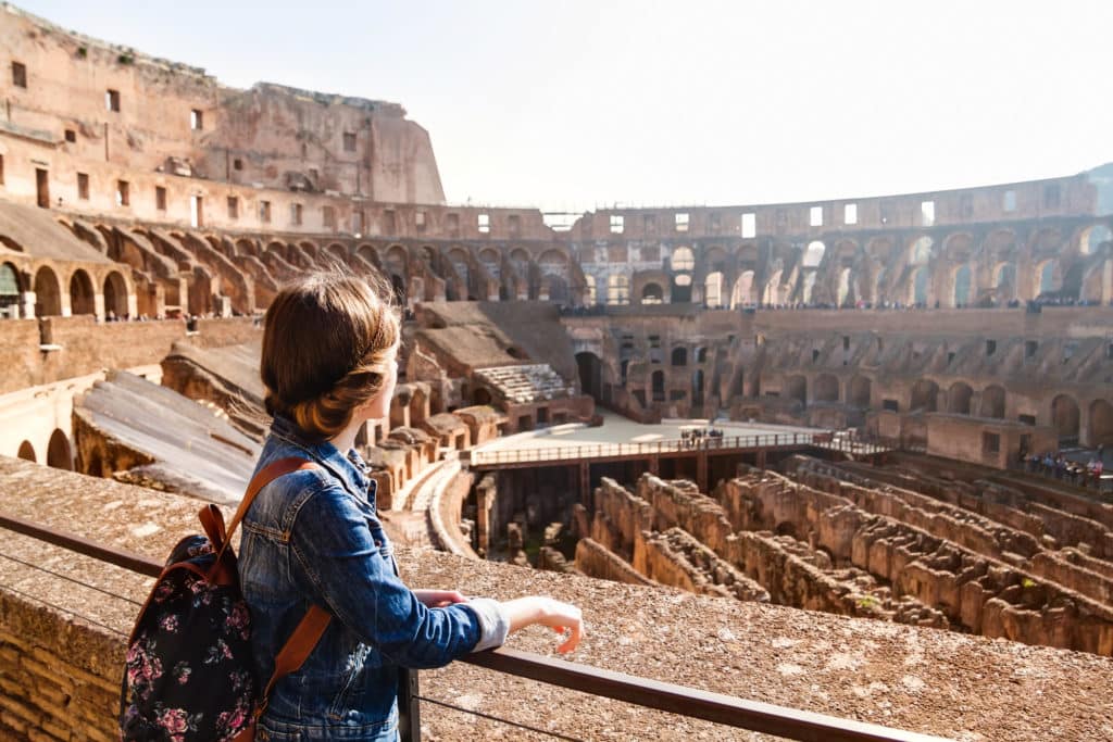 Young girl with backpack exploring inside the Colosseum (Coliseum). Rome, Italy